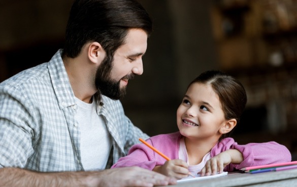 father and daughter writing note to put in time capsule | Coastline Realty