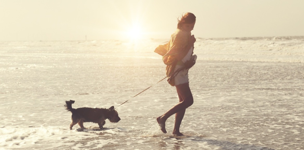 woman and dog on topsail beach | Coastline Realty Vacations