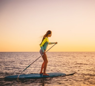 woman paddleboarding on topsail island | Coastline Realty Vacations