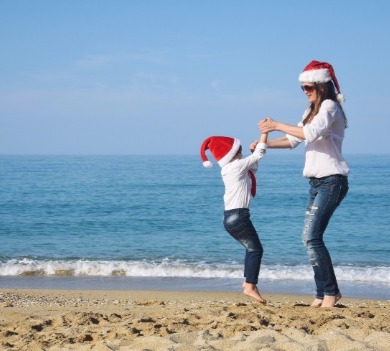 mother and daughter in santa hats at the beach | Coastline Realty Vacations
