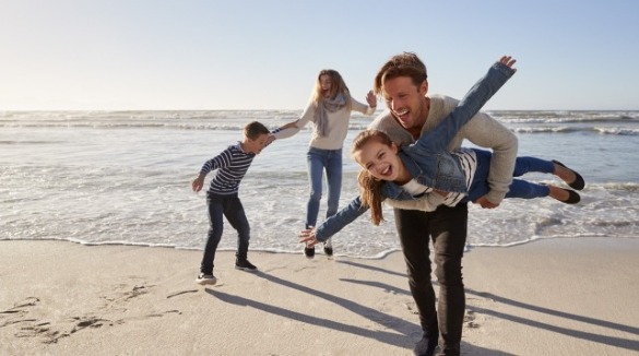 family enjoying the beach during Fall | Coastline Realty
