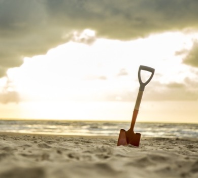small shovel on the beach | Coastline Realty